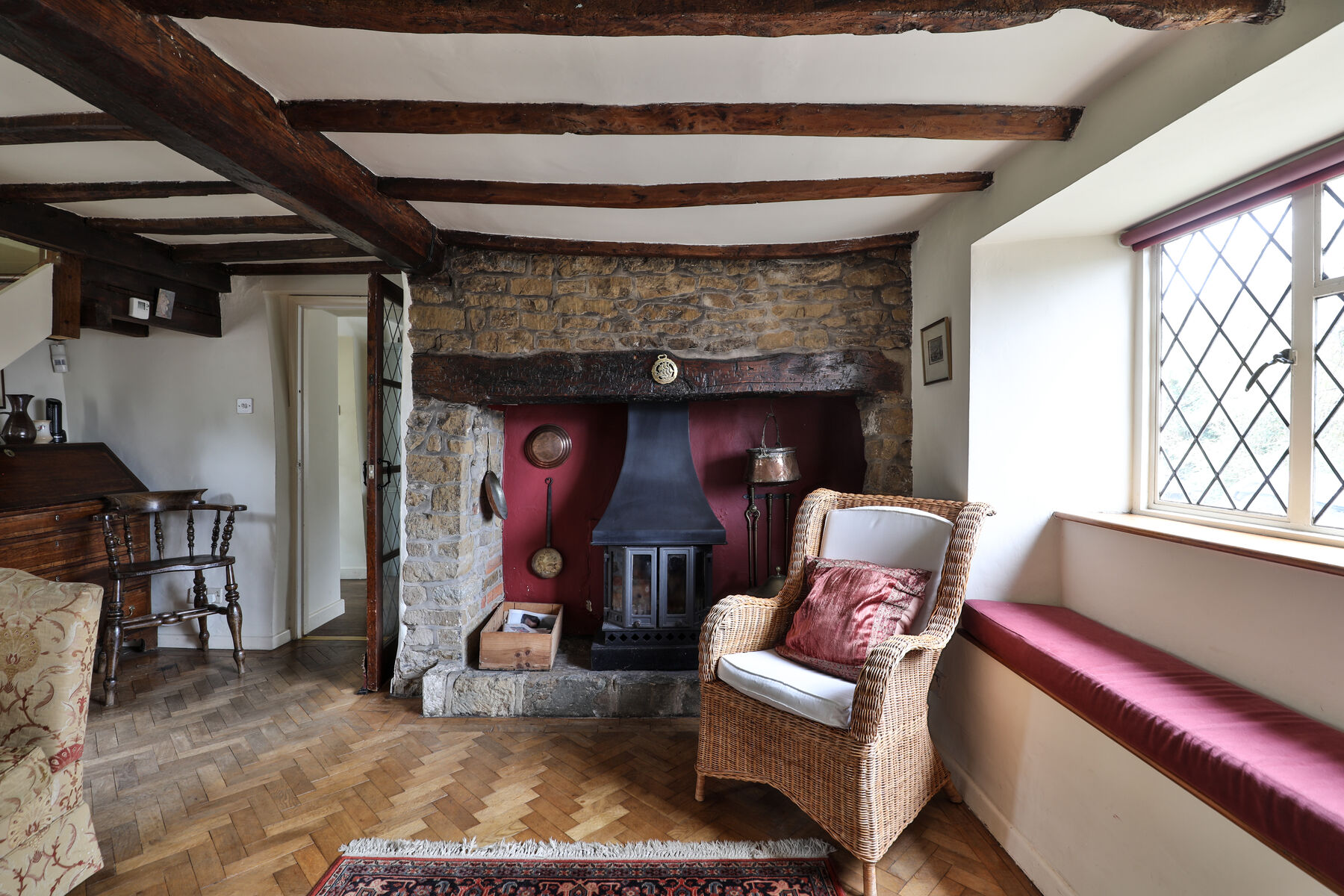 The beamed living room with oak beams and a window seat